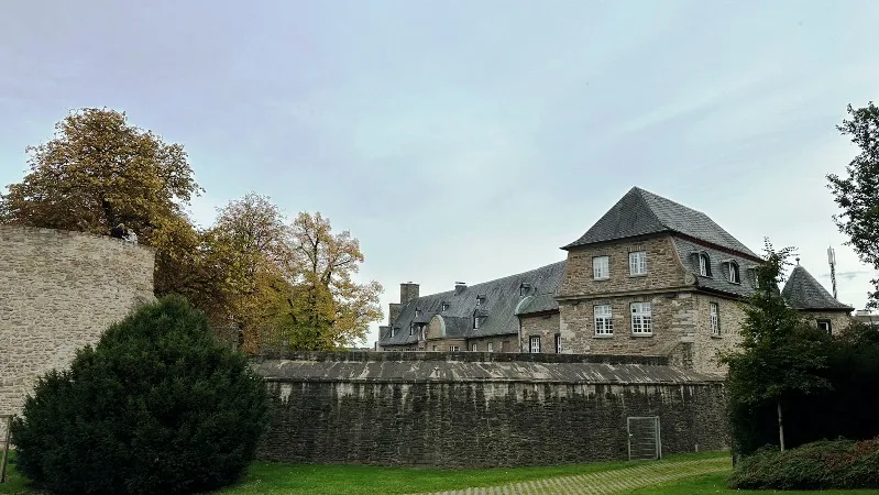 Blick auf die imposante Außenfassade von Schloss Broich in Mülheim, umgeben von Grün und historischer Architektur.