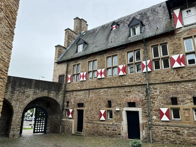 Mittelalterlicher Charme im Innenhof von Schloss Broich in Mülheim, umgeben von dicken Steinwänden.