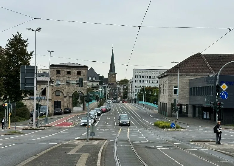 Ansicht der Stadt Mülheim an der Ruhr vom Schloss Broich aus. Im Vordergrund die historische Schlossbrücke, im Hintergrund die Stadtmitte von Mülheim mit modernen und historischen Gebäuden.