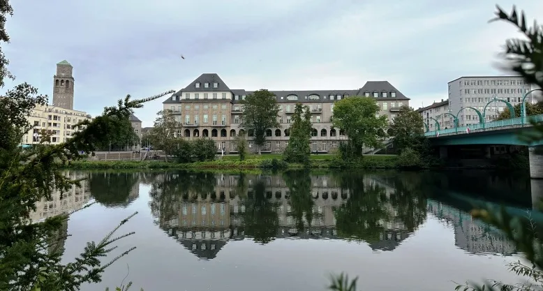 Ansicht der Ruhr und des Ufers an der Ruhrpromenade in der Innenstadt von er Stadt Mülheim an der Ruhr, umgeben von Grünflächen und städtischer Architektur.