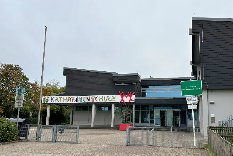 Schulen in Mülheim - Außenansicht der Katharienschule in Mülheim, umgeben von Bäumen und einem blauen Himmel.