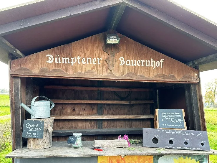 Der Dümptener Bauernhof in Mülheim, ein idyllischer landwirtschaftlicher Betrieb mit traditionellen Gebäuden, grünen Feldern und einem klaren Himmel im Hintergrund. Auf dem Hof sind verschiedene Tiere wie Kühe und Hühner zu sehen, die das ländliche Leben widerspiegeln