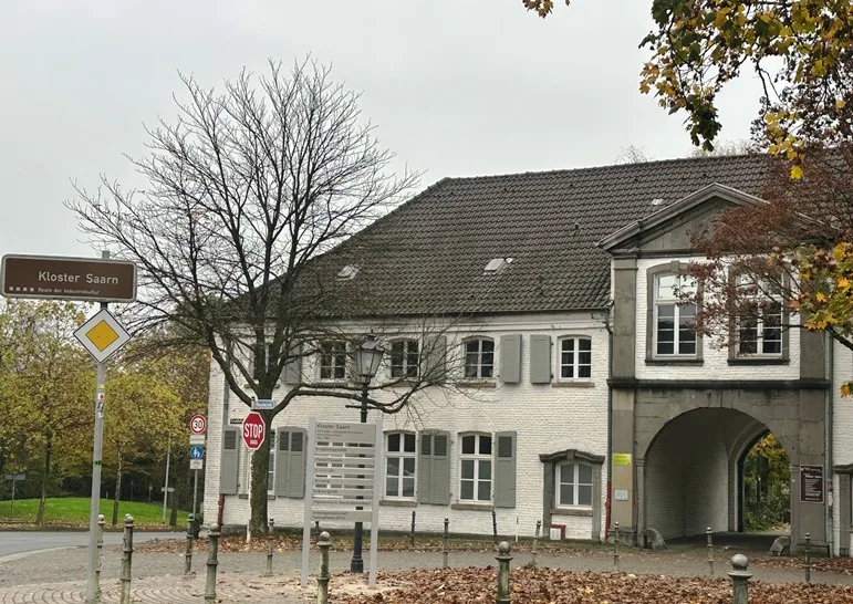 Außenansicht von Kloster Saarn in Mülheim, umgeben von gepflegten Grünanlagen und traditioneller Architektur.