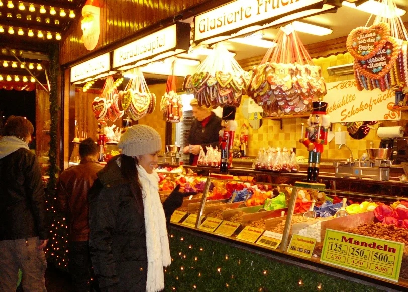 Weihnachtsmarkt in Mülheim 2024 bei Nacht, festlich beleuchtete Buden, geschmückte Tannenbäume und Menschen, die den Markt besuchen